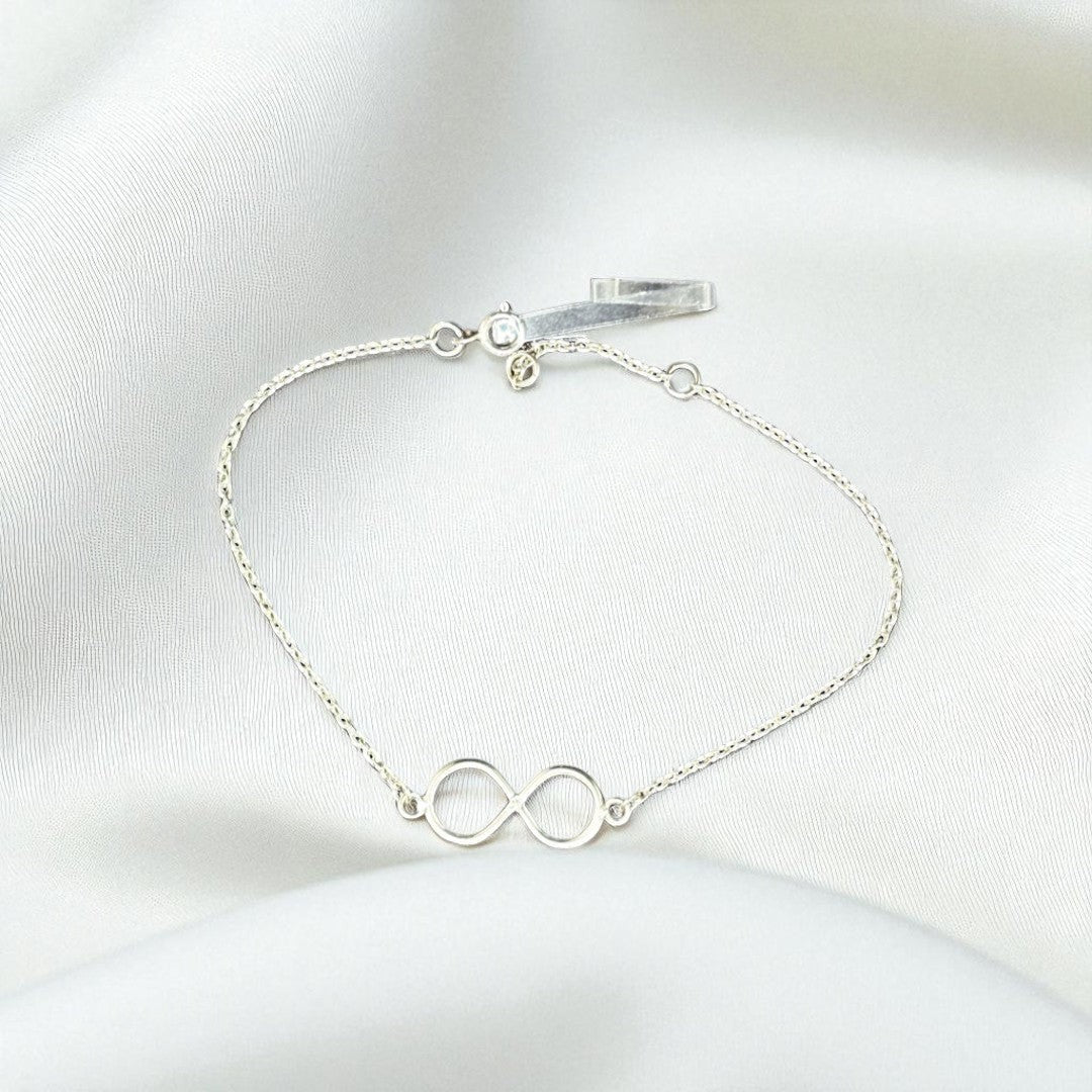 BlingbyAnvika 925 sterling silver infinity symbol bracelet on a soft white satin background