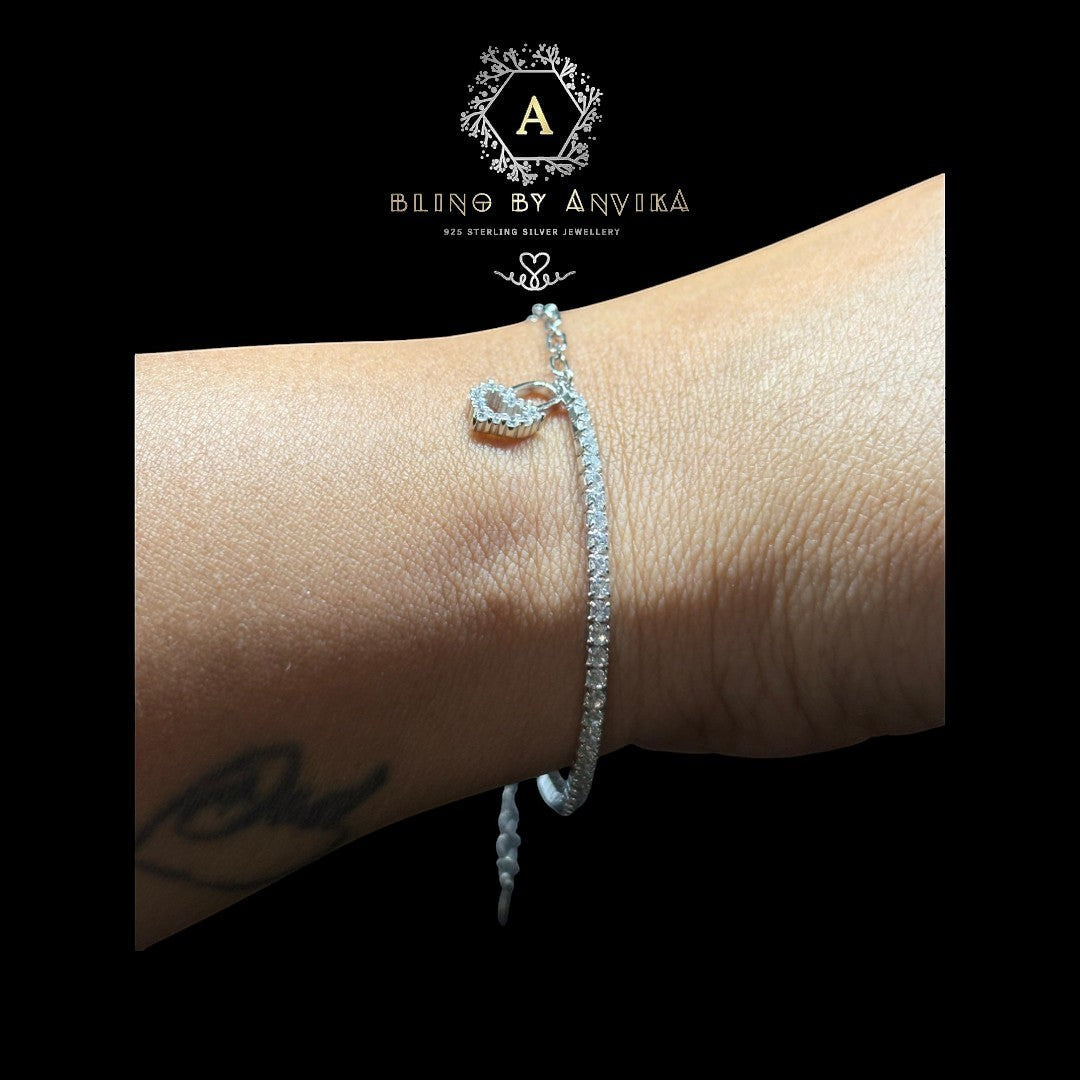 BlingbyAnvika 925 sterling silver tennis bracelet with sparkling cubic zirconia and infinity symbol charm.