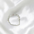 BlingbyAnvika 925 silver infinity link chain bracelet with sparkling accents on a white satin background