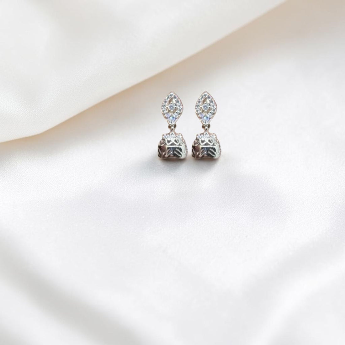 BlingbyAnvika 925 sterling silver jhumka earrings with intricate detailing and small clear stones.