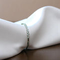 BlingbyAnvika 925 sterling silver bracelet featuring a delicate leaf design with shimmering stones on white fabric.