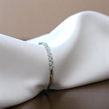 BlingbyAnvika 925 sterling silver bracelet featuring a delicate leaf design with shimmering stones on white fabric.