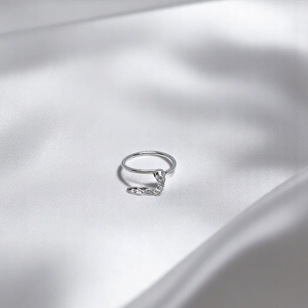 BlingbyAnvika 925 sterling silver nose ring featuring a delicate hanging leaf charm on a white satin background.