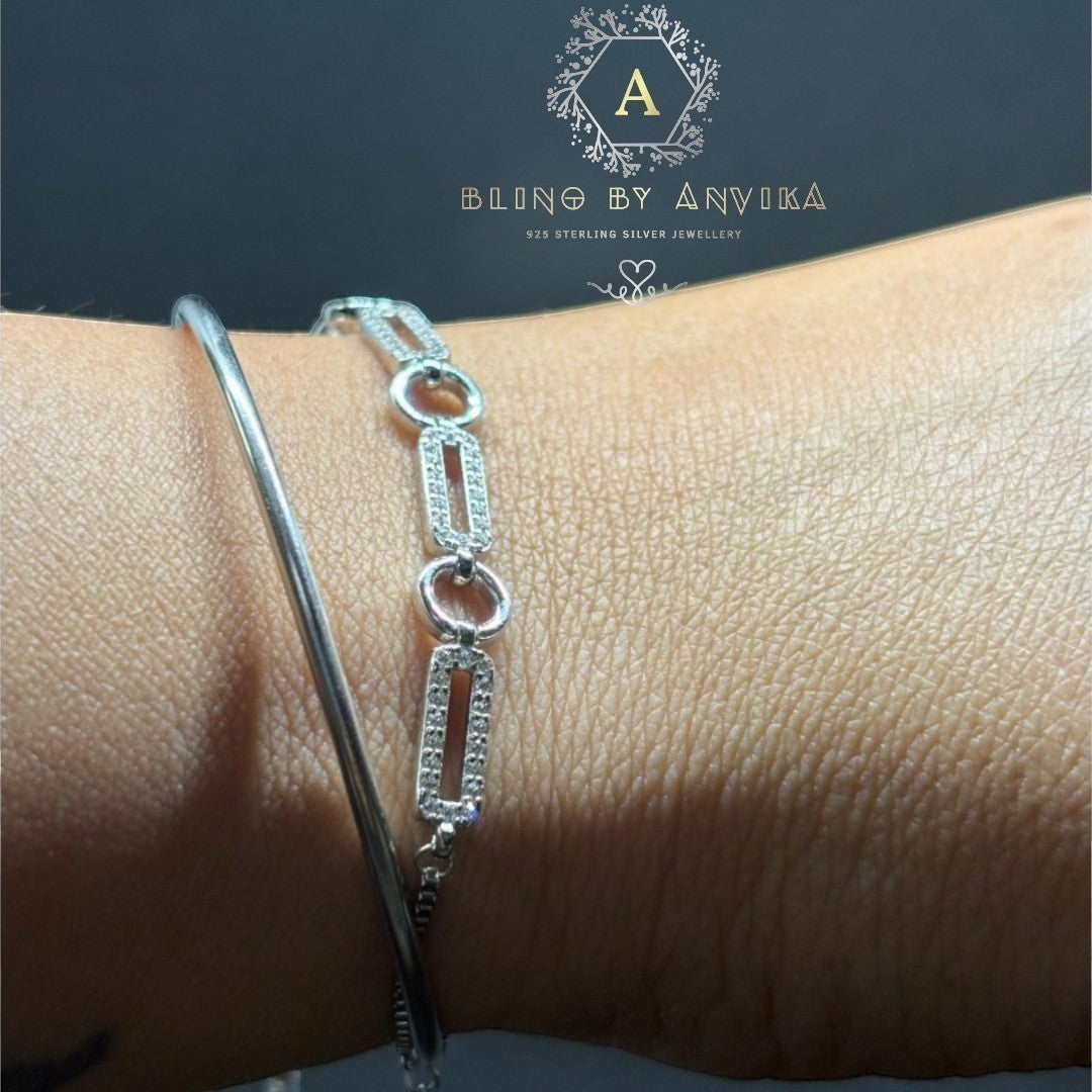 BlingbyAnvika 925 sterling silver linked chain bracelet with pavé accents worn on a wrist next to a sleek silver kada.