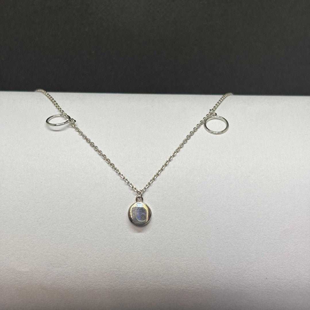 BlingbyAnvika sterling silver necklace with oval iridescent pendant and two circle accents. Minimalist design.