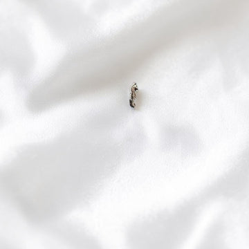 BlingbyAnvika 925 sterling silver seahorse nose pin with intricate detailing on a grey concrete surface.