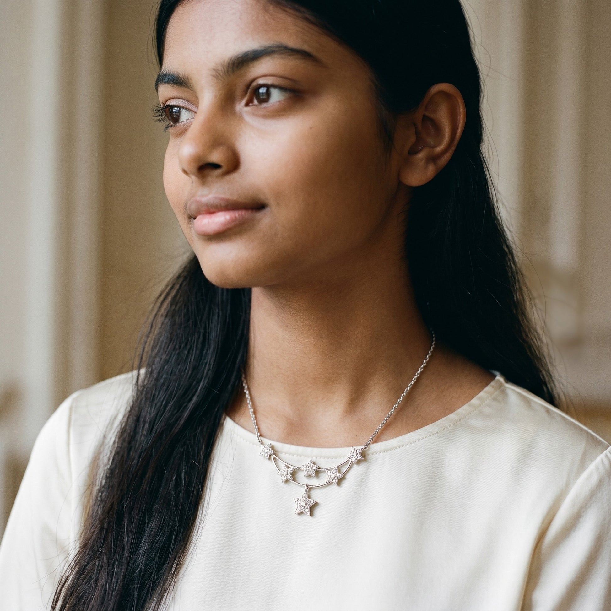 BlingbyAnvika 925 sterling silver necklace with a delicate star pendant and five small stars along a curved chain.