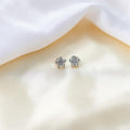 BlingbyAnvika sterling silver star stud earrings with sparkling AAA-grade zircon stones on white satin fabric.