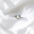 BlingbyAnvika sterling silver star stud earrings featuring sparkling AAA-grade zircon stones on white satin fabric.
