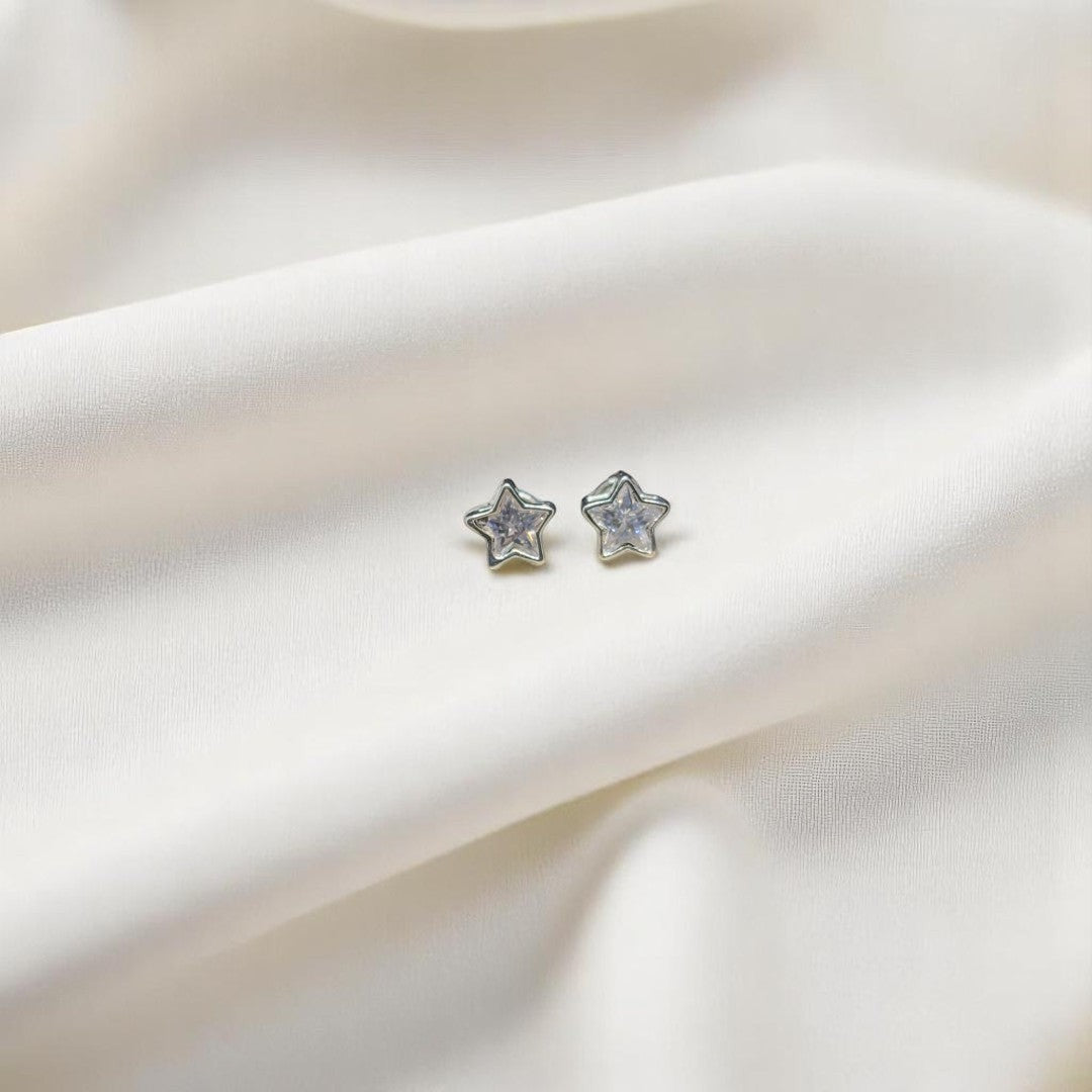 BlingbyAnvika sterling silver star stud earrings with sparkling AAA-grade zircon stones on white draped fabric.