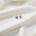 BlingbyAnvika sterling silver star stud earrings with sparkling AAA-grade zircon stones on white draped fabric.