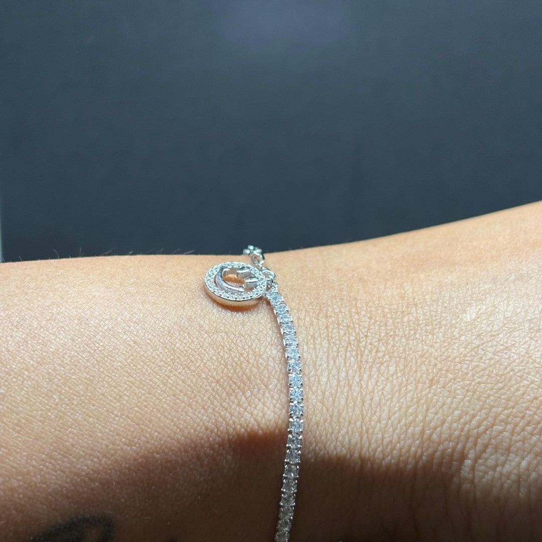 BlingbyAnvika 925 sterling silver tennis bracelet with a circular charm, adorned with small stones.