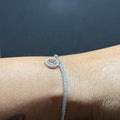 BlingbyAnvika 925 sterling silver tennis bracelet with a circular charm, adorned with small stones.