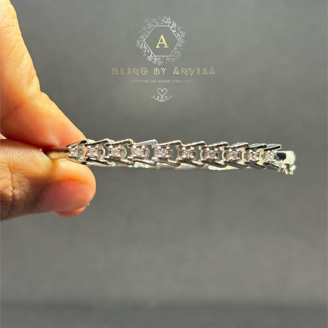 BlingbyAnvika 925 sterling silver link bracelet featuring geometric links and brilliant-cut stones held by a hand.