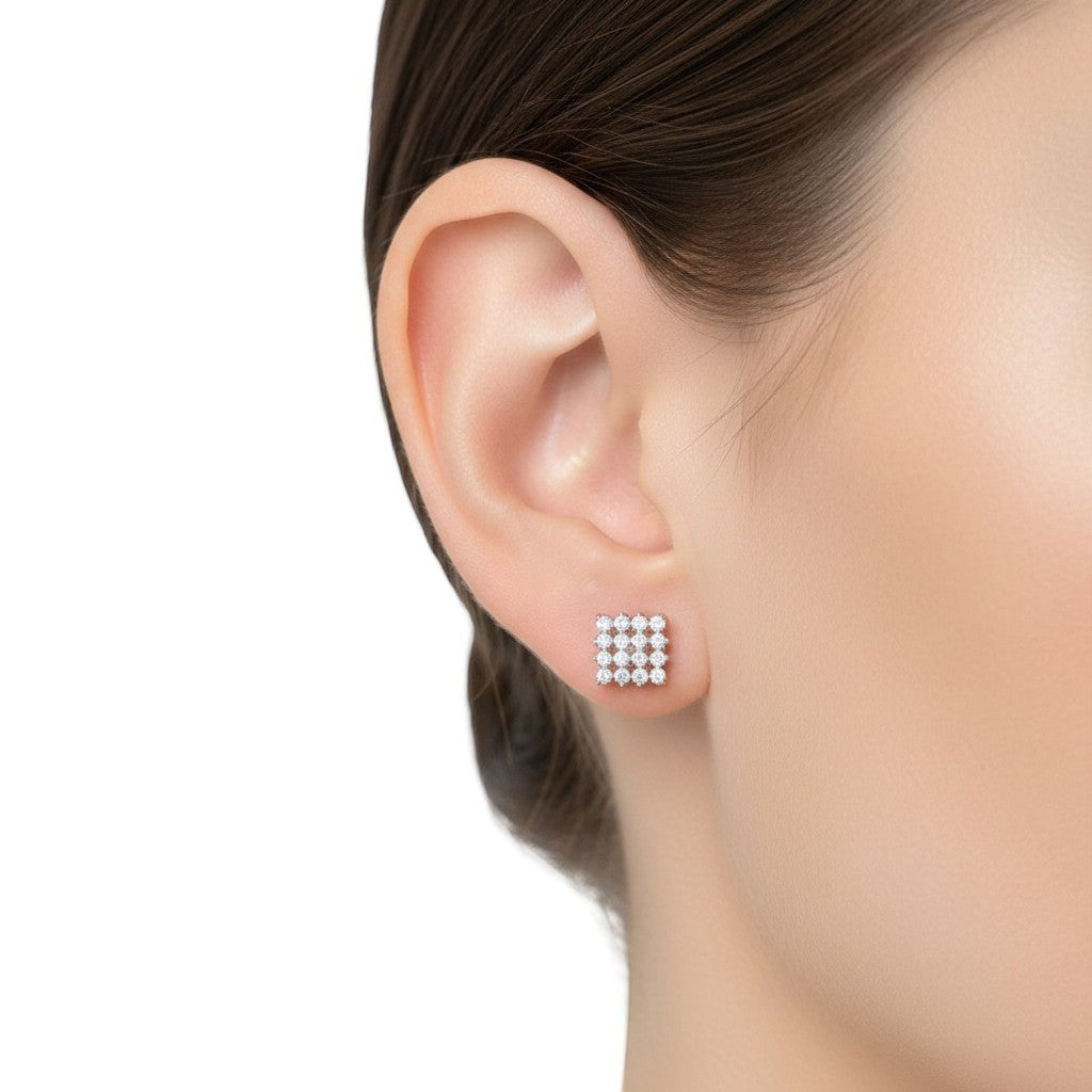 BlingbyAnvika square sterling silver stud earrings with sparkling AAA-grade zircon stones on white silk fabric.