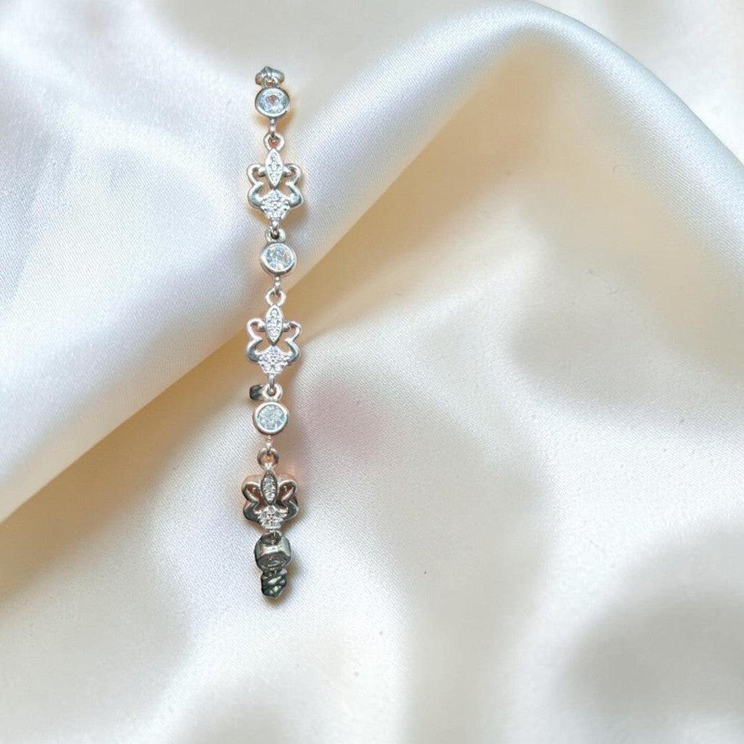 BlingbyAnvika sterling silver bolo bracelet with cubic zirconia and fleur-de-lis charms. Adjustable clasp.