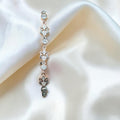 BlingbyAnvika sterling silver bolo bracelet with cubic zirconia and fleur-de-lis charms. Adjustable clasp.