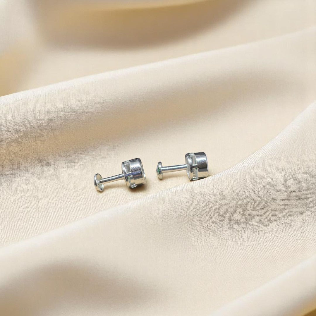 BlingbyAnvika 925 sterling silver stud earrings with vibrant green stones on a soft beige fabric background.