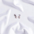 BlingbyAnvika sterling silver stud earrings featuring three sparkling AAA-grade zircon stones on white fabric.