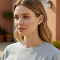 BlingbyAnvika sterling silver stud earrings with AAA-grade zircon stones worn by a woman in a casual grey t-shirt