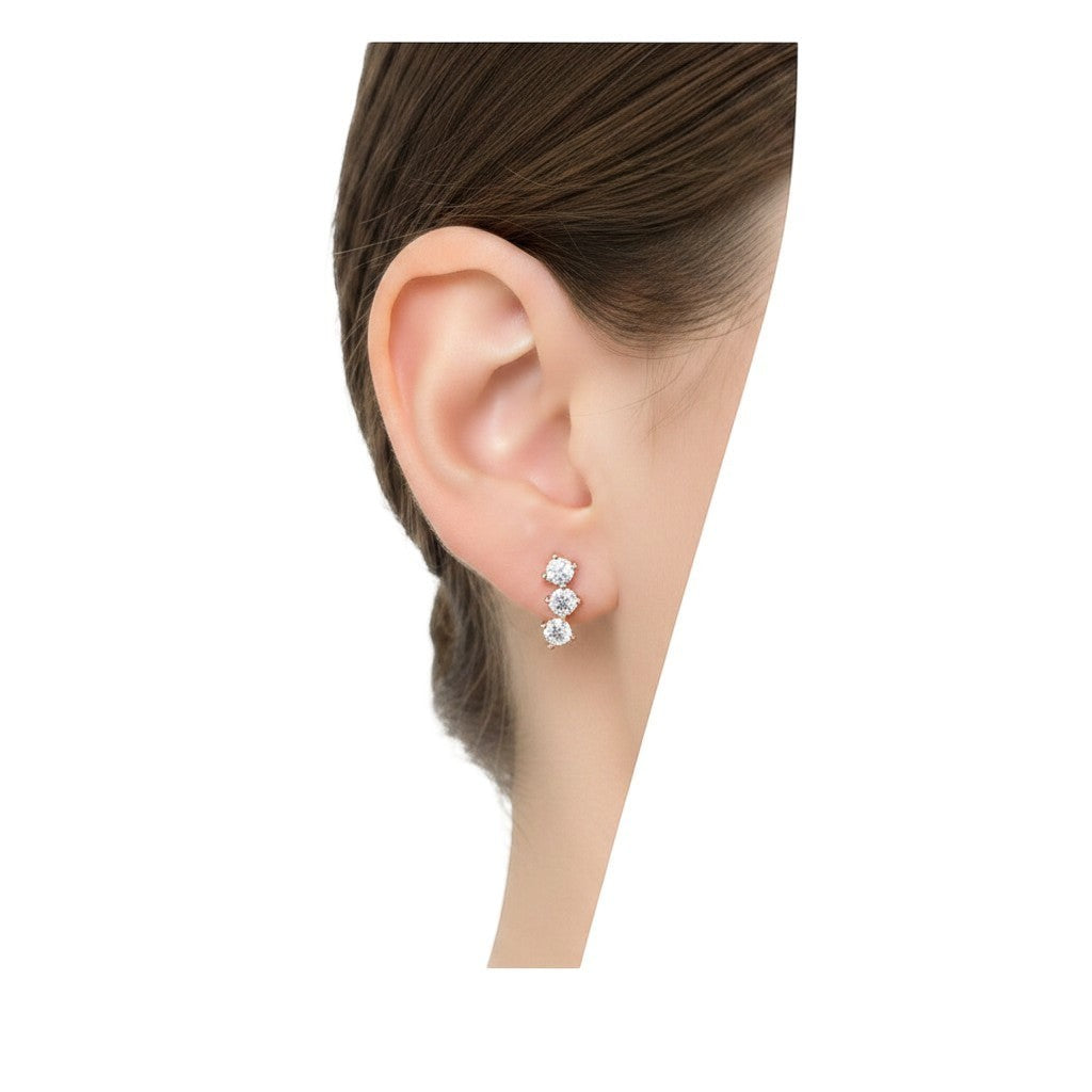 BlingbyAnvika sterling silver stud earrings featuring three sparkling AAA-grade zircon stones on white fabric.